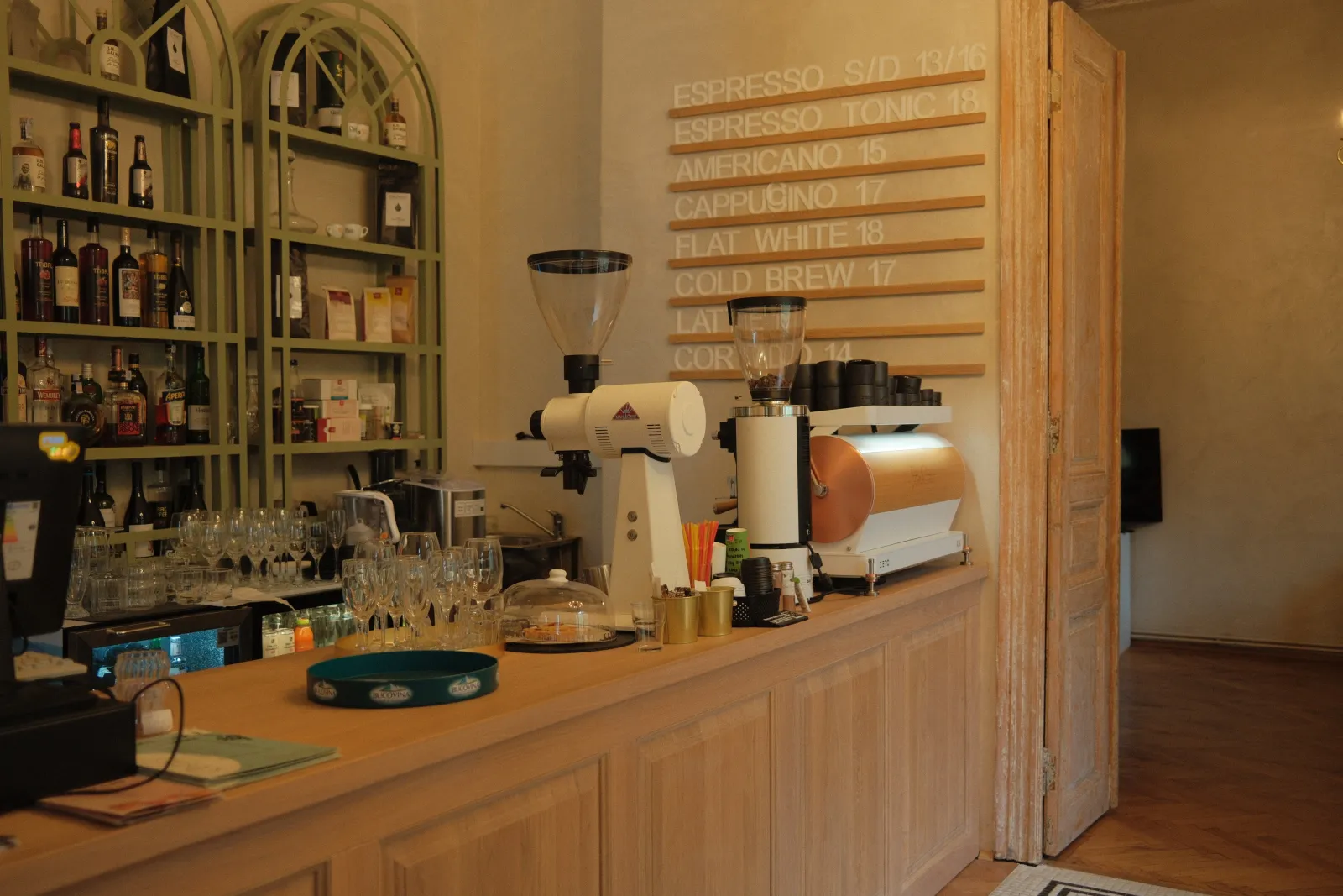 The Mélange coffee bar, grinders and menu wall in warm light