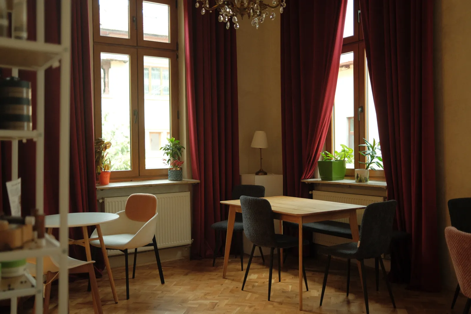 The sitting room, red velvet curtains and a wooden table by the window