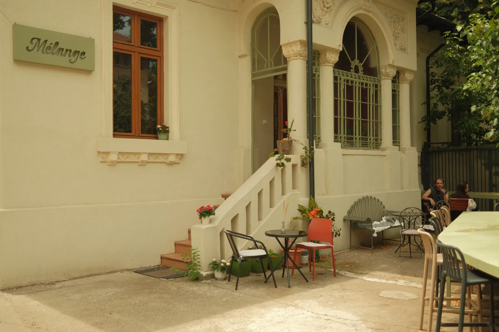 Two people talking over coffee on the terrace of Mélange, the villa café Nookyard lives in